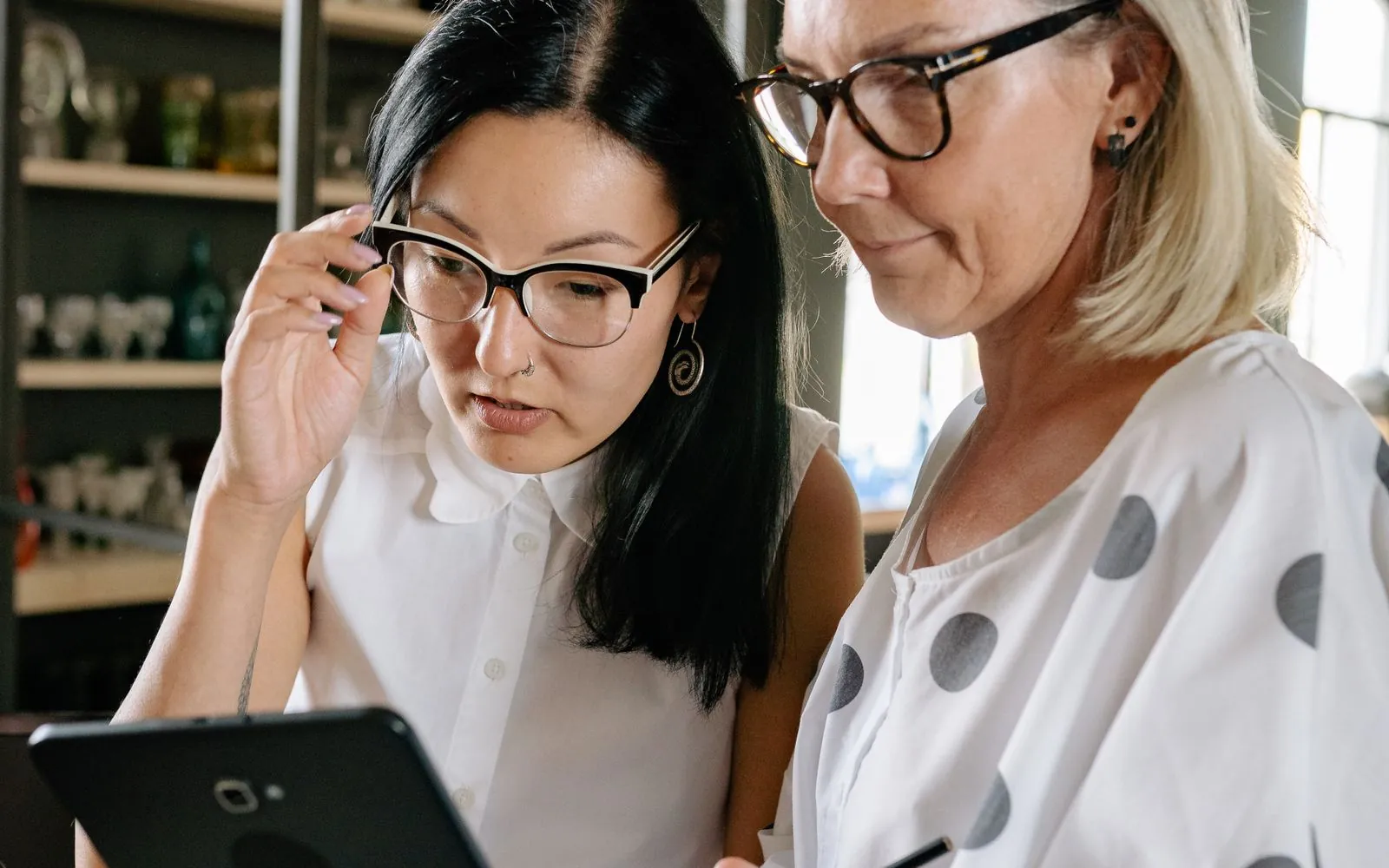 Two front desk team members collaborating at a computer inside a clinic